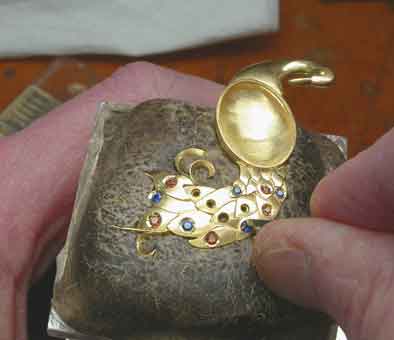 Setting the gems: Once the feathers have been dapped out and soldered together and the cast body has been finished and soldered to the tail, gem setting can begin, the method is known as thread and bead setting.Peacock Pendant: Micro view, all gems set.