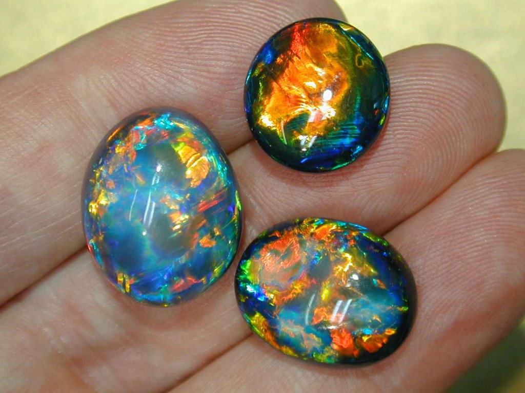 Three black opals showing two tones of body color.  The Australian valuing system recognizes nine degrees of body tone.